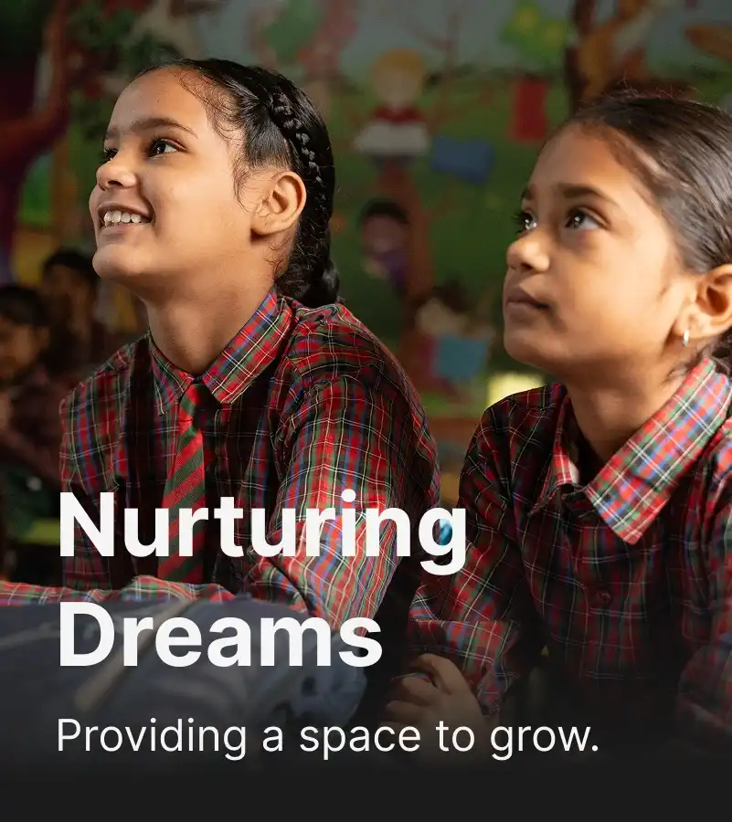 Two schoolgirls in plaid uniforms sitting in a colorful classroom with an overlaid Text “Nurturing Dreams – Providing a space to grow
